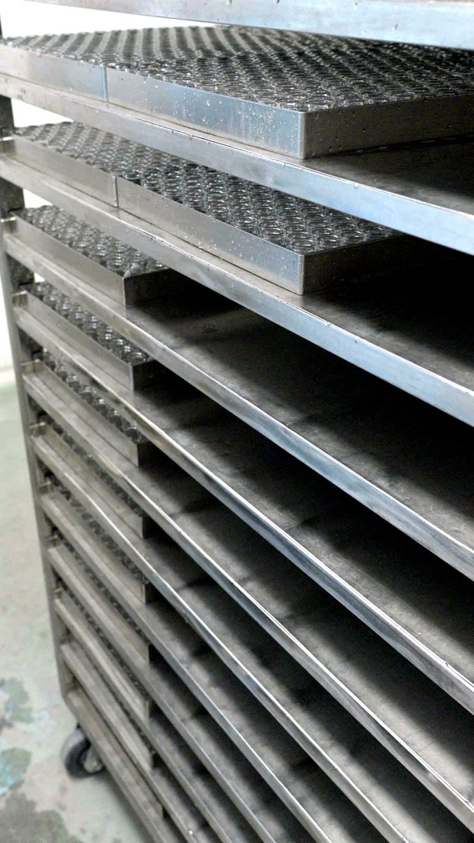 Trays of vials stacked on stainless-steel shelving